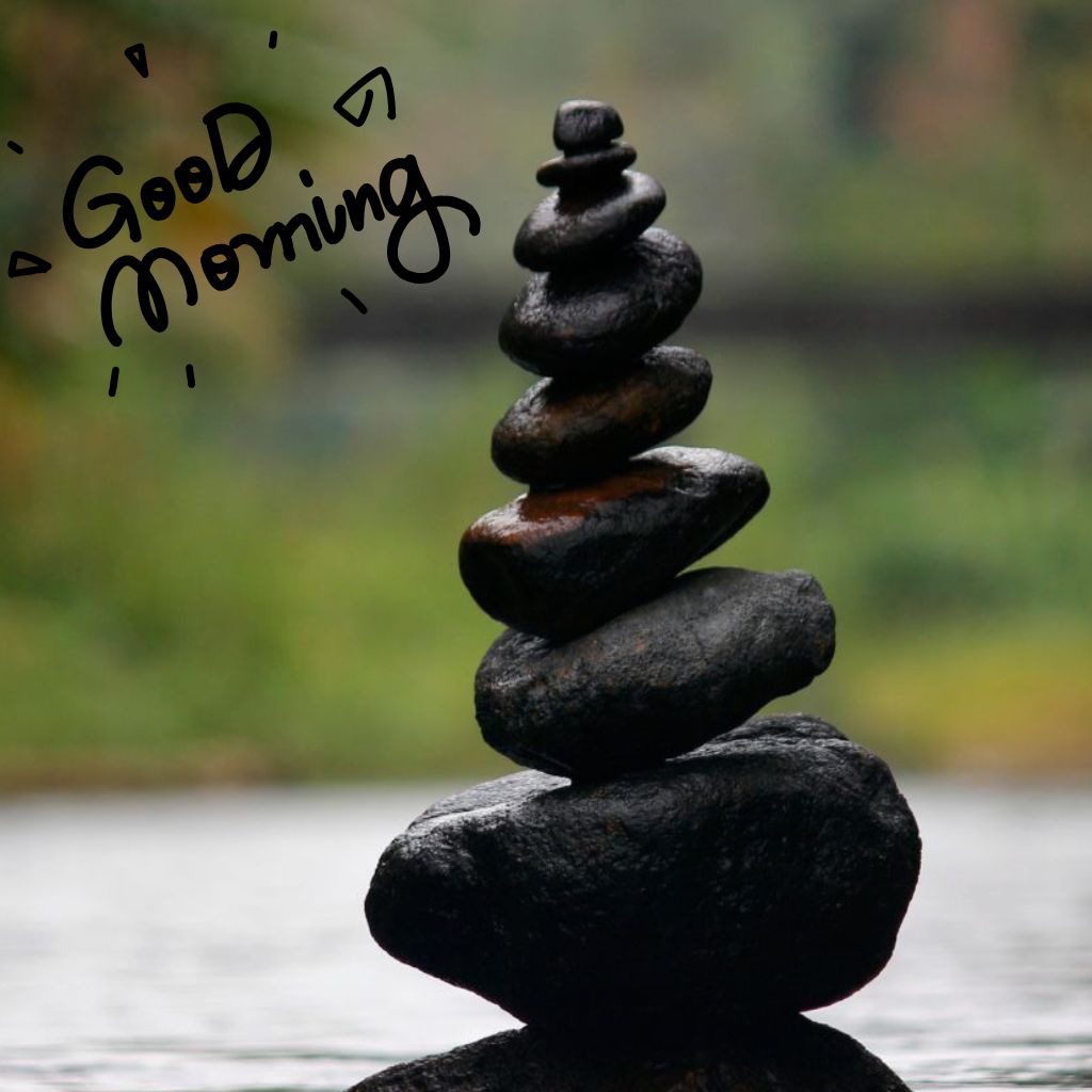 Balanced black stones over water with handwritten “Good Morning”
A balanced stack of smooth black stones over calm water, featuring hand-drawn “Good Morning” text above them.